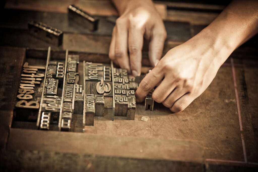 a pair of hands arrange letters for letterpress 103005733 5a1ddbc7c7822d001a96758b