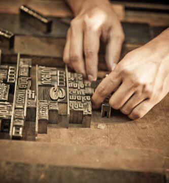 a pair of hands arrange letters for letterpress 103005733 5a1ddbc7c7822d001a96758b