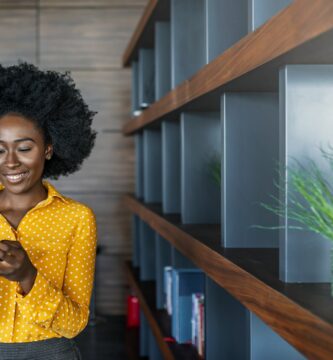 business woman reading text message on mobile phone 1173954417 019857ba417f4f298862cb92e6f3ce95