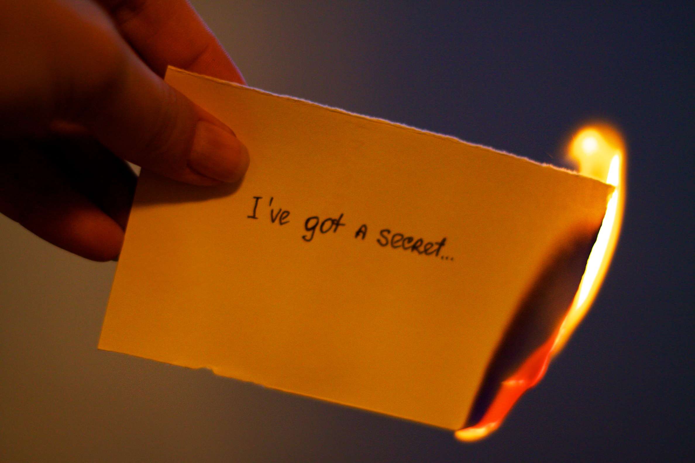 Papír v plamenech, který říká "Mám tajemství ..."