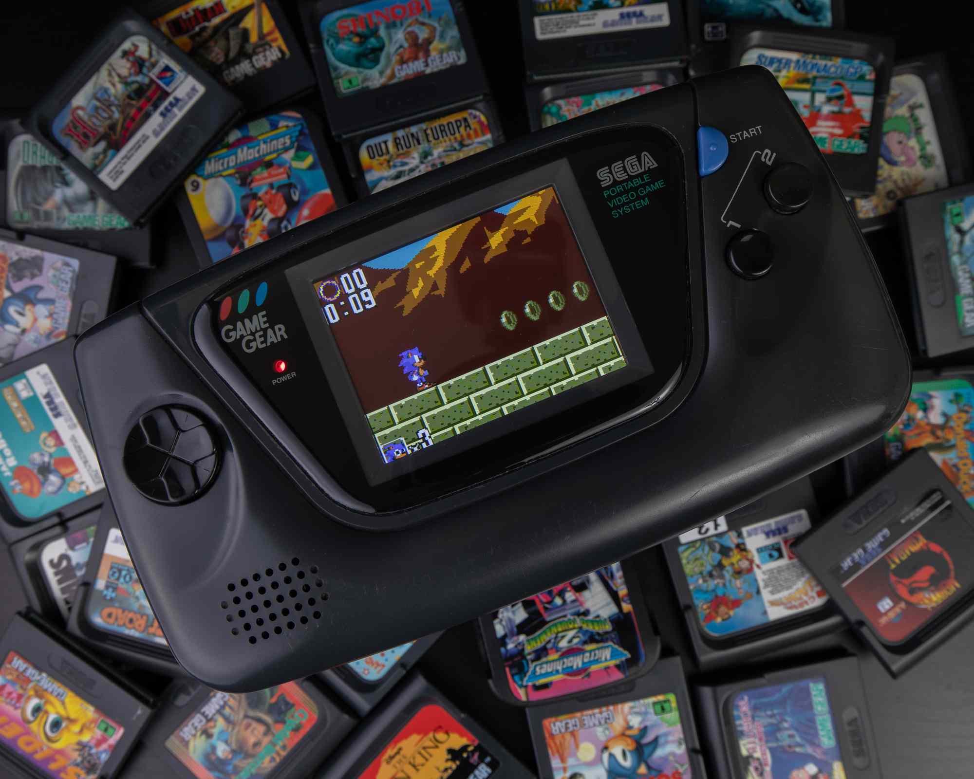 Konzole Sega obklopená herními kazetami.