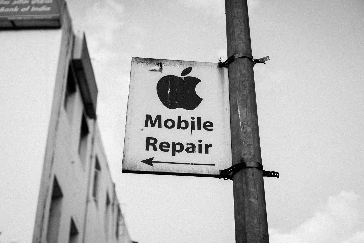 Pouliční cedule s nápisem „Mobile Repair“ pod logem Apple