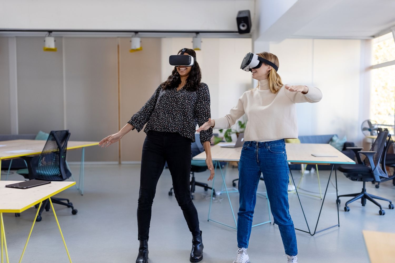 Dva lidé používající VR headsety v kancelářském prostředí.