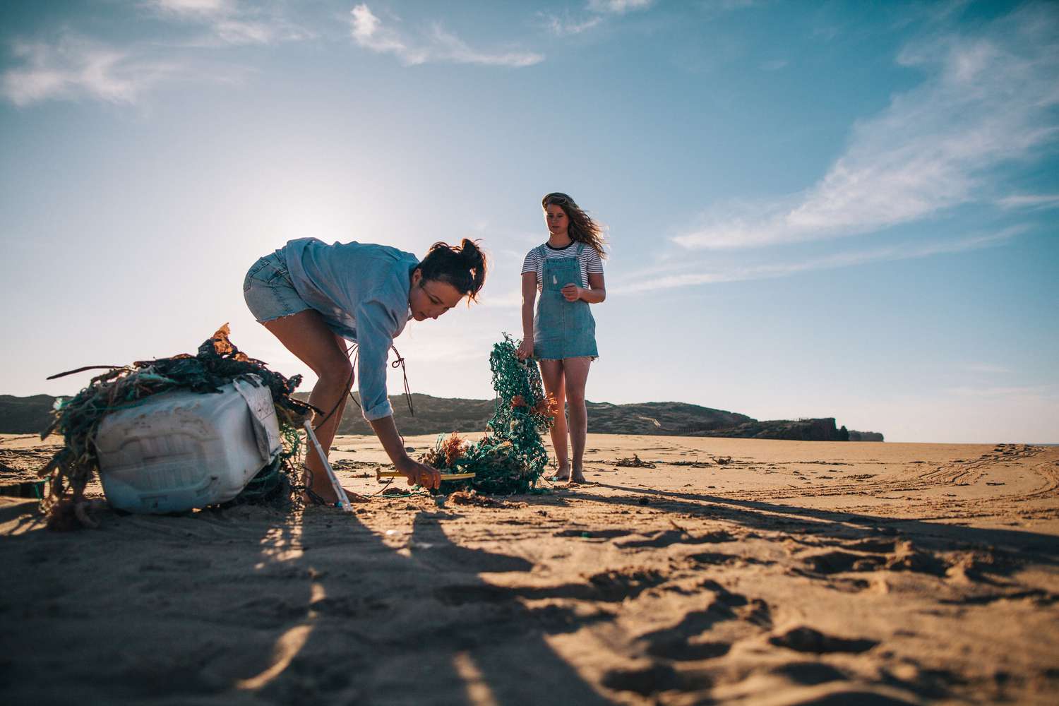 Dvě ženy sbírající odpadky na pláži